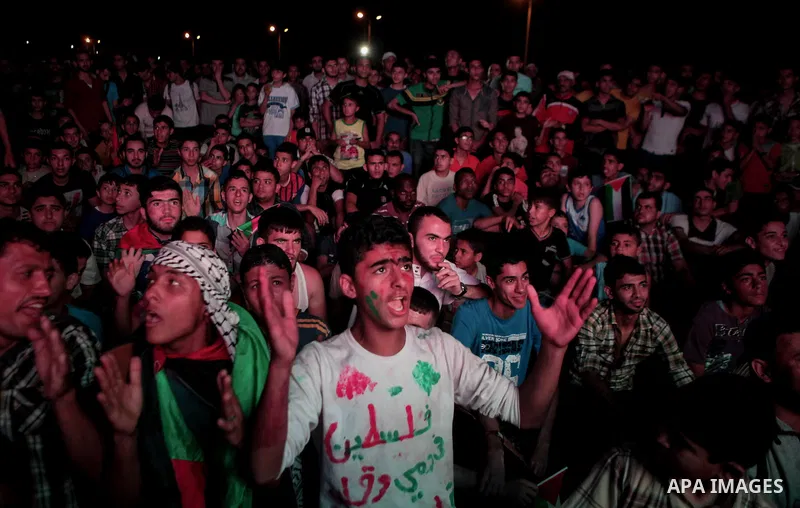 Palestinians celebrate in Gaza City on May 30, 2014, after Palestine qualified for their maiden Asian Cup appearance with a 1-0 win over injury-hit Philippines in the final of the AFC Challenge Cup in Maldives. Photo by...