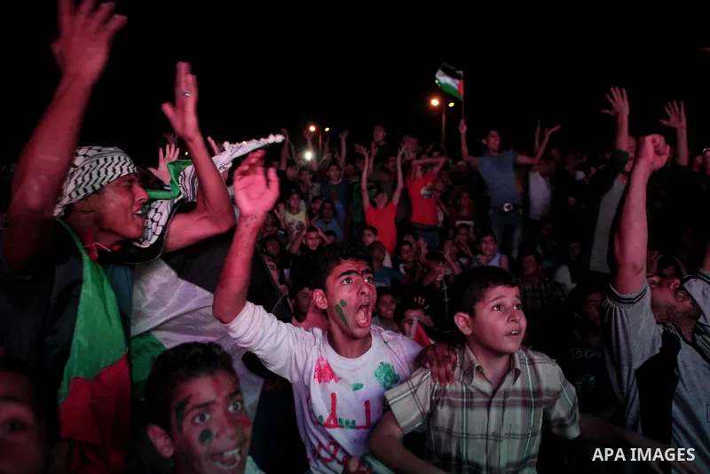 Palestinians celebrate in Gaza City on May 30, 2014, after Palestine qualified for their maiden Asian Cup appearance with a 1-0 win over injury-hit Philippines in the final of the AFC Challenge Cup in Maldives. Photo by...