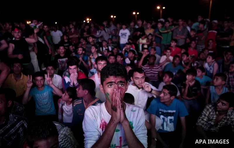 Palestinians cheer as they watch the soccer match between their national team and Philippines on large screens during the AFC Cup Final, in Gaza City May 30, 2014. Photo by Ezz Zanoun