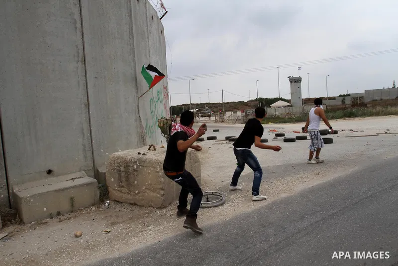 Protesters hurl stones at Israeli forces responding with tear gas during clashes near the West Bank city of Tulkarem, 31 May 2014. Reportedly dozens of Palestinians were injured during clashes with Israeli forces after p...