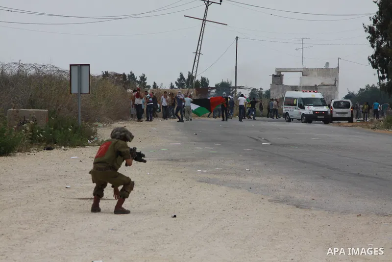 An Israeli soldier fires tear gas at Palestinian protesters responding with stones during clashes near the West Bank city of Tulkarem, 31 May 2014. Reportedly dozens of Palestinians were injured during clashes with Israe...