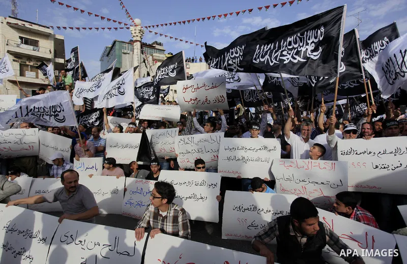 Palestinian supporters of Hizb ut-Tahrir wave black and white flags as they take part in a rally marking the anniversary of the fall of the Islamic Caliphate, in the West Bank city of Ramallah May 31, 2014. Photo by Issa...