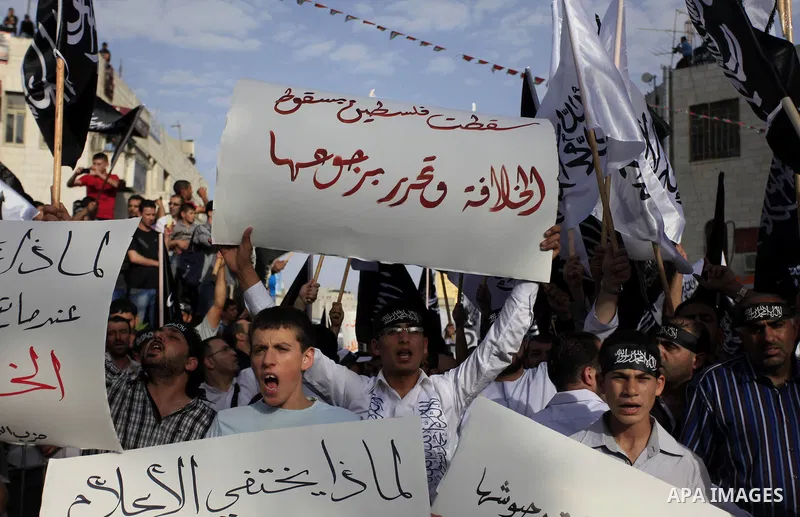 Palestinian supporters of Hizb ut-Tahrir wave black and white flags as they take part in a rally marking the anniversary of the fall of the Islamic Caliphate, in the West Bank city of Ramallah May 31, 2014. Photo by Issa...