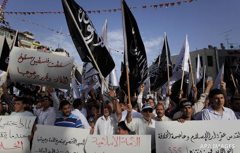 Palestinian supporters of Hizb ut-Tahrir wave black and white flags as they take part in a rally marking the anniversary of the fall of the Islamic Caliphate, in the West Bank city of Ramallah May 31, 2014. Photo by Issa...