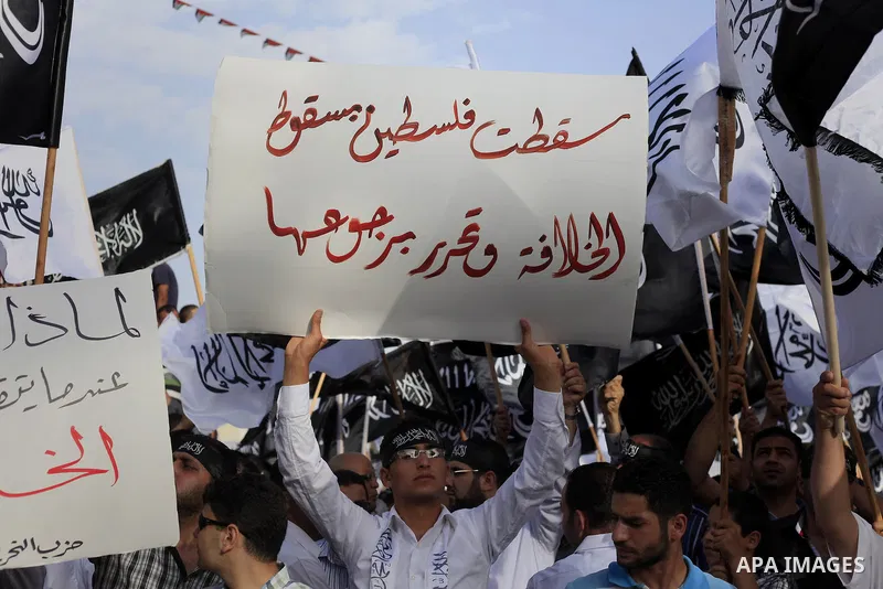 Palestinian supporters of Hizb ut-Tahrir wave black and white flags as they take part in a rally marking the anniversary of the fall of the Islamic Caliphate, in the West Bank city of Ramallah May 31, 2014. Photo by Issa...