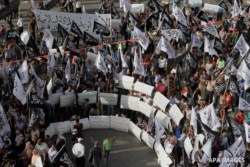 Palestinian supporters of Hizb ut-Tahrir wave black and white flags as they take part in a rally marking the anniversary of the fall of the Islamic Caliphate, in the West Bank city of Ramallah May 31, 2014. Photo by Issa...
