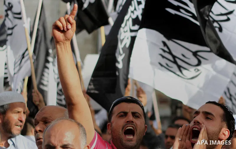 Palestinian supporters of Hizb ut-Tahrir wave black and white flags as they take part in a rally marking the anniversary of the fall of the Islamic Caliphate, in the West Bank city of Ramallah May 31, 2014. Photo by Issa...