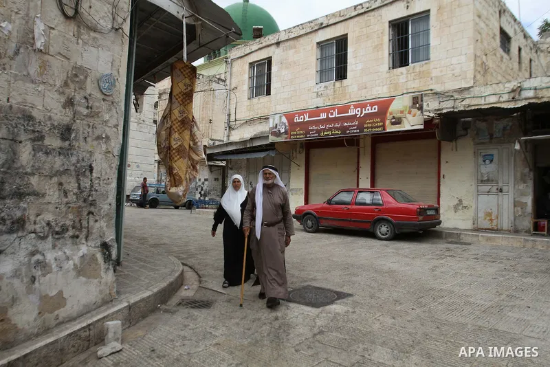 Palestinians walk past a closed shop during a strike to solidarity with Palestinian prisoners on hunger strike held in Israeli jails, in the West Bank city of Nablus on June 1, 2014. Photo by Nedal Eshtayah