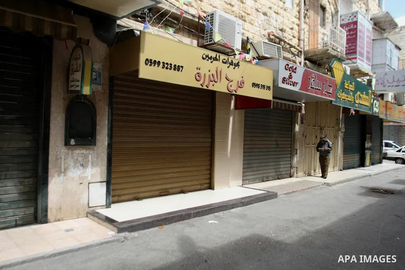 A Palestinian man walks past a closed shop during a strike to solidarity with Palestinian prisoners on hunger strike held in Israeli jails, in the West Bank city of Nablus on June 1, 2014. Photo by Nedal Eshtayah