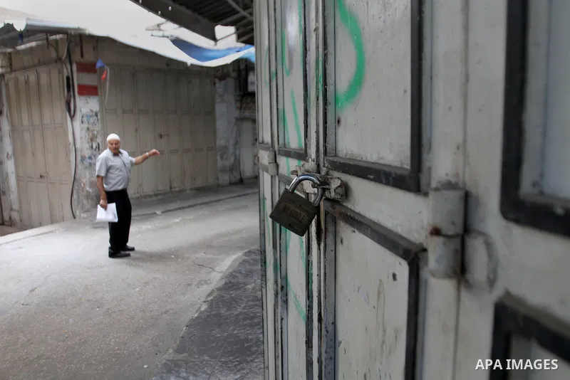 A Palestinian man walks past a closed shop during a strike to solidarity with Palestinian prisoners on hunger strike held in Israeli jails, in the West Bank city of Nablus on June 1, 2014. Photo by Nedal Eshtayah