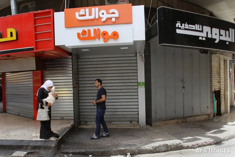Palestinians walk past a closed shop during a strike to solidarity with Palestinian prisoners on hunger strike held in Israeli jails, in the West Bank city of Nablus on June 1, 2014. Photo by Nedal Eshtayah