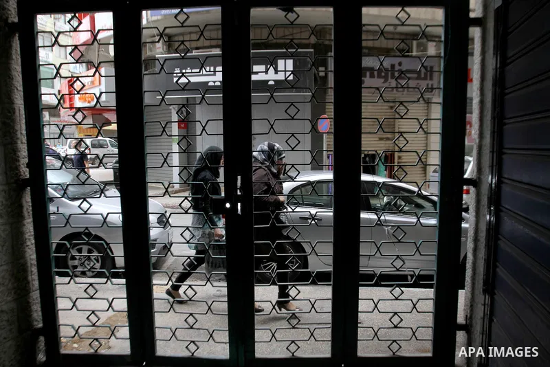 Palestinians walk past a closed shop during a strike to solidarity with Palestinian prisoners on hunger strike held in Israeli jails, in the West Bank city of Nablus on June 1, 2014. Photo by Nedal Eshtayah