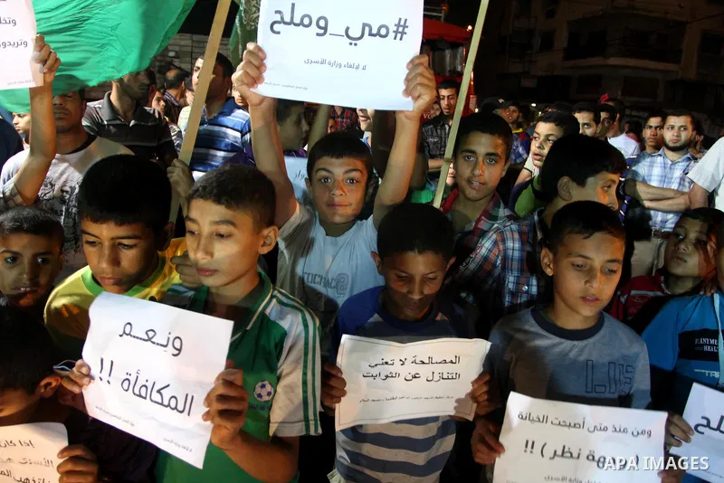Palestinian children hold placards during a protest against dissolving the ministry of prisoners in the new unity government, in Gaza City on June 1, 2014. The new Palestinian unity government will be sworn in, on Monday...