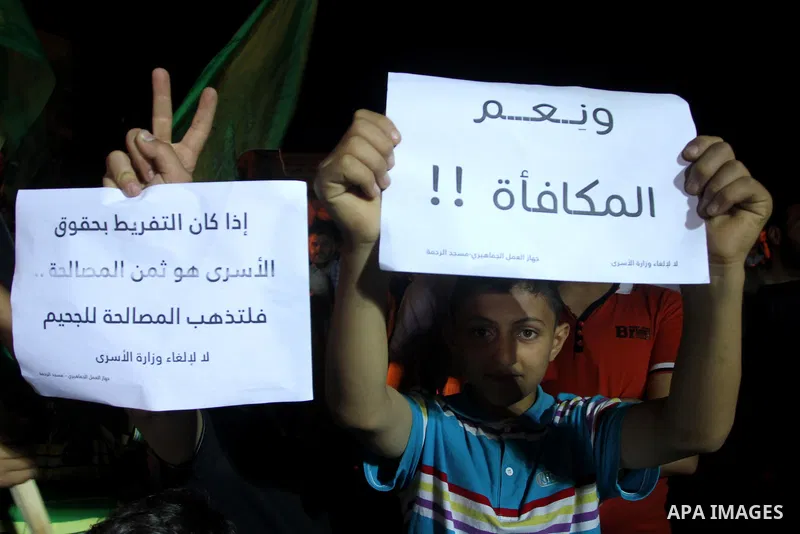 Palestinian children hold placards during a protest against dissolving the ministry of prisoners in the new unity government, in Gaza City on June 1, 2014. The new Palestinian unity government will be sworn in, on Monday...