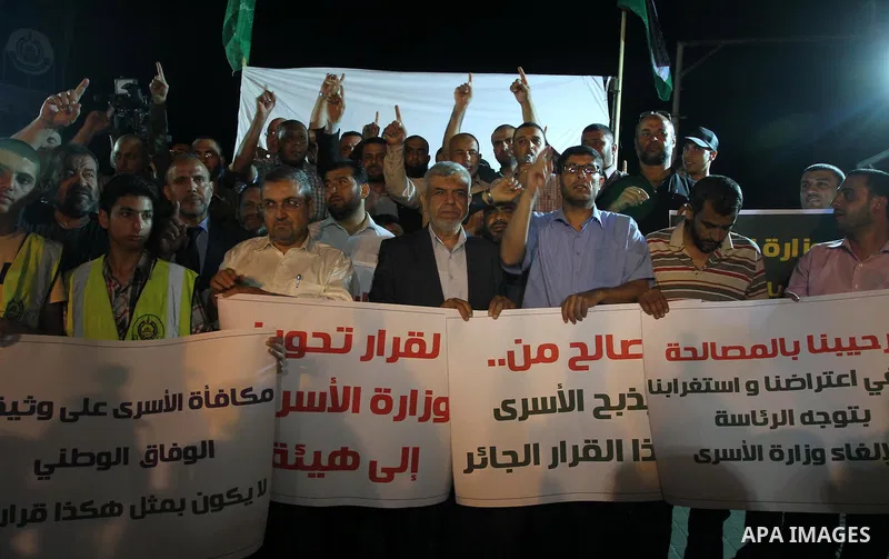 Palestinians hold placards during a protest against dissolving the ministry of prisoners in the new unity government, in Gaza City on June 1, 2014. The new Palestinian unity government will be sworn in, on Monday, at the...