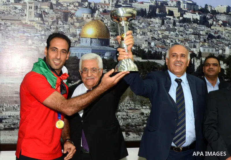 Palestinian President Mahmoud Abbas receives the Palestinian national football team which won the AFC Challenge Cup, at Abbas's office in the West Bank city of Ramallah on June 1, 2014. Palestine qualified for their maid...
