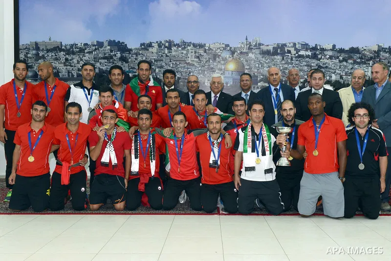 Palestinian President Mahmoud Abbas receives the Palestinian national football team which won the AFC Challenge Cup, at Abbas's office in the West Bank city of Ramallah on June 1, 2014. Palestine qualified for their maid...
