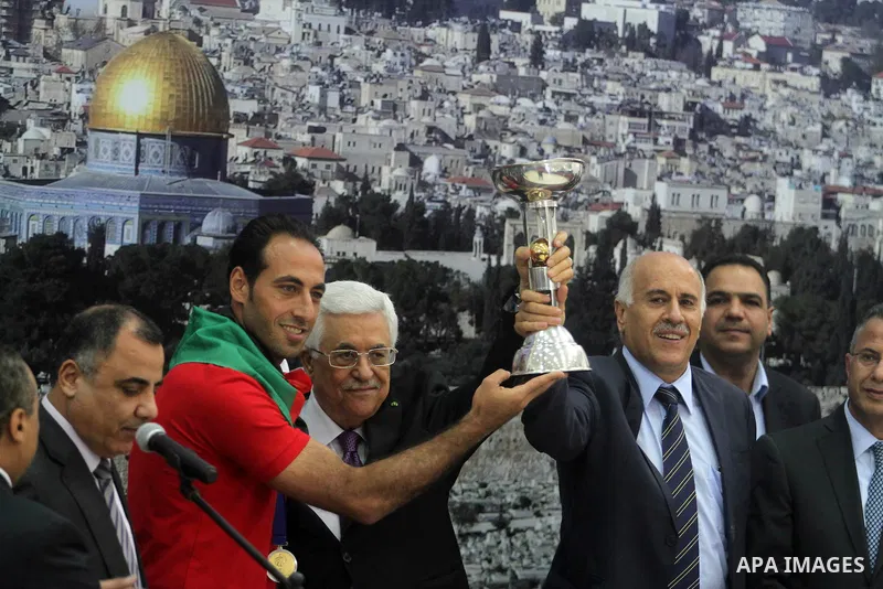 Palestinian President Mahmoud Abbas receives the Palestinian national football team which won the AFC Challenge Cup, at Abbas's office in the West Bank city of Ramallah on June 1, 2014. Palestine qualified for their maid...