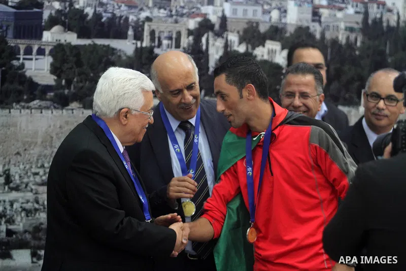Palestinian President Mahmoud Abbas receives the Palestinian national football team which won the AFC Challenge Cup, at Abbas's office in the West Bank city of Ramallah on June 1, 2014. Palestine qualified for their maid...
