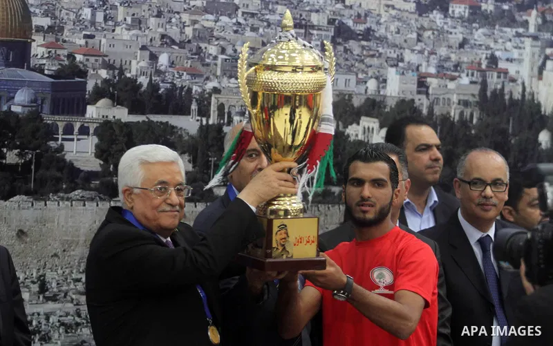 Palestinian President Mahmoud Abbas receives the Palestinian national football team which won the AFC Challenge Cup, at Abbas's office in the West Bank city of Ramallah on June 1, 2014. Palestine qualified for their maid...