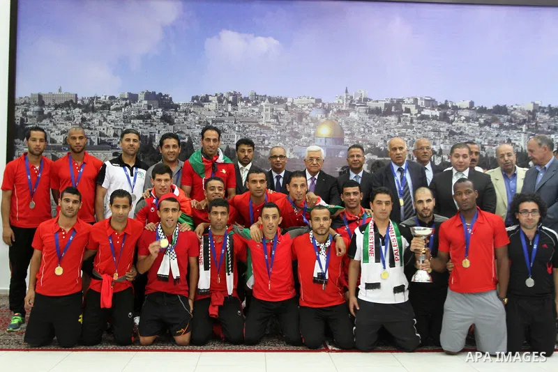 Palestinian President Mahmoud Abbas receives the Palestinian national football team which won the AFC Challenge Cup, at Abbas's office in the West Bank city of Ramallah on June 1, 2014. Palestine qualified for their maid...