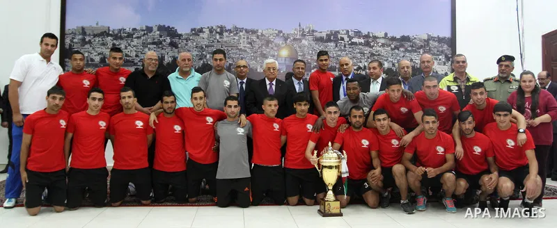 Palestinian President Mahmoud Abbas receives the Palestinian national football team which won the AFC Challenge Cup, at Abbas's office in the West Bank city of Ramallah on June 1, 2014. Palestine qualified for their maid...