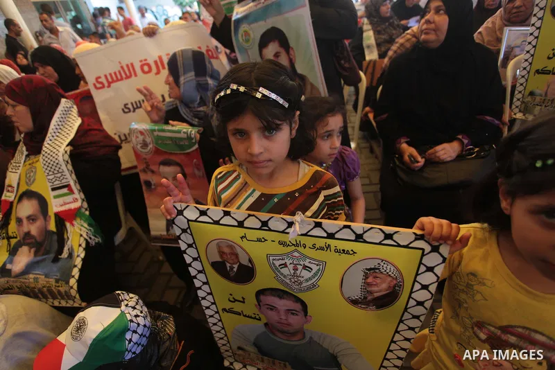 Palestinians hold posters of Prisoners during a rally to show solidarity with Palestinian prisoners held in Israeli jails, in front of Red cross office in Gaza City June 2, 2014. Some 120 Palestinians jailed without tria...