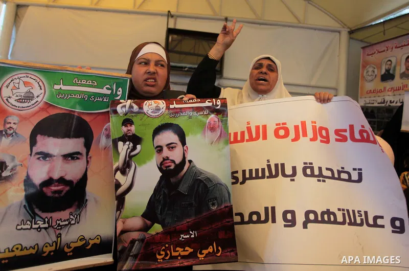 Palestinians hold posters of Prisoners during a rally to show solidarity with Palestinian prisoners held in Israeli jails, in front of Red cross office in Gaza City June 2, 2014. Some 120 Palestinians jailed without tria...