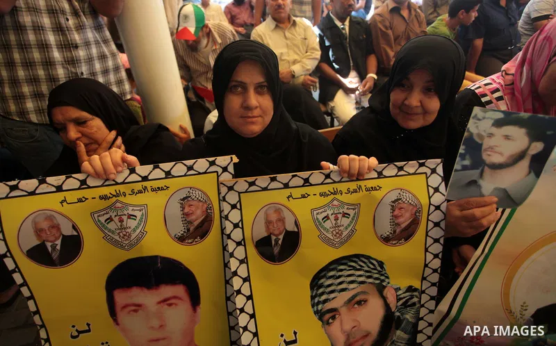 Palestinians hold posters of Prisoners during a rally to show solidarity with Palestinian prisoners held in Israeli jails, in front of Red cross office in Gaza City June 2, 2014. Some 120 Palestinians jailed without tria...