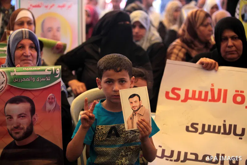 Palestinians hold posters of Prisoners during a rally to show solidarity with Palestinian prisoners held in Israeli jails, in front of Red cross office in Gaza City June 2, 2014. Some 120 Palestinians jailed without tria...