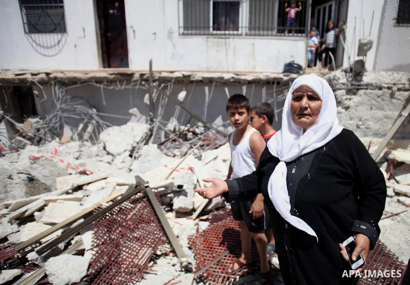 Palestinians look at the rubble of a store following demolished their sheds by Israeli bulldozers, in Ras al-Amud in Jerusalem on June 02, 2014. Israel destroyed more than 500 Palestinian properties in the West Bank and...