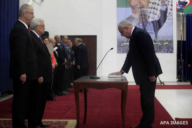 Palestinian Foreign Minister Riyad Al-Maliki is sworn in along with the new Palestinian unity government in the presence of Palestinian president Mahmud Abbas (L) in the West Bank city of Ramallah June 2, 2014. Abbas hai...