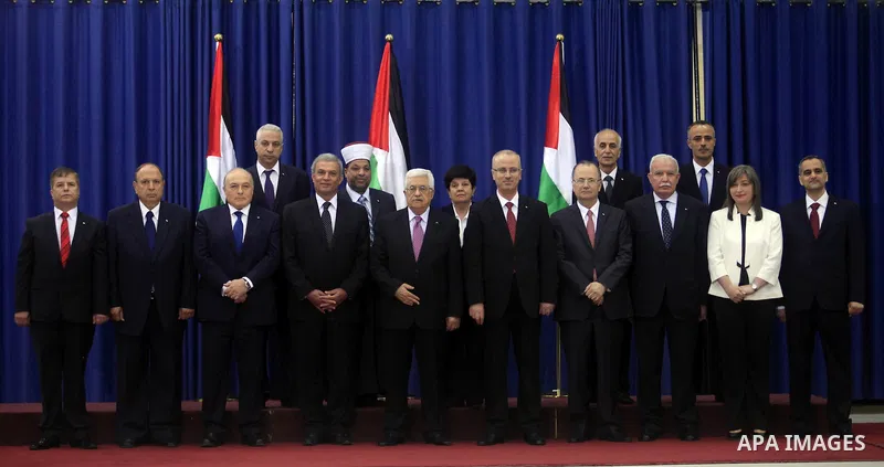 Palestinian president Mahmud Abbas (C) poses for a picture with the members of the new Palestinian unity government in the West Bank city of Ramallah June 2, 2014. Abbas hailed the "end" of Palestinian division as a new...