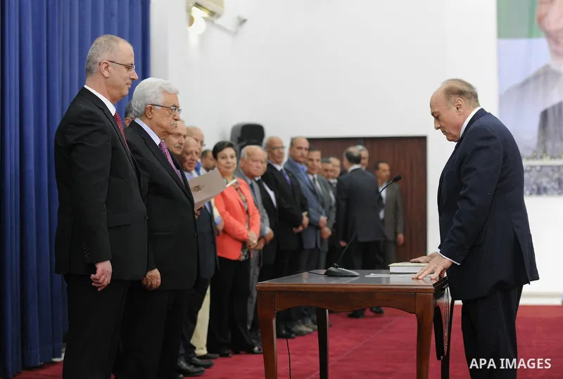 Palestinian President Mahmoud Abbas and the new unity government Prime Minister Rami Hamdallah during the swearing in ceremony of the government at the Palestinian Authority's headquarters in the West Bank town of Ramall...
