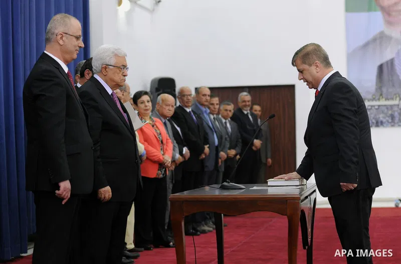 Palestinian President Mahmoud Abbas and the new unity government Prime Minister Rami Hamdallah during the swearing in ceremony of the government at the Palestinian Authority's headquarters in the West Bank town of Ramall...