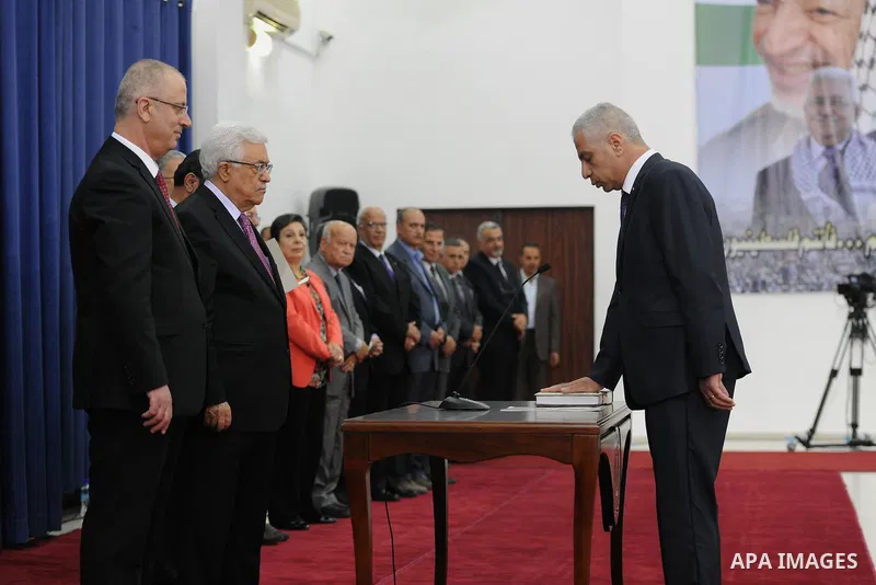 Palestinian President Mahmoud Abbas and the new unity government Prime Minister Rami Hamdallah during the swearing in ceremony of the government at the Palestinian Authority's headquarters in the West Bank town of Ramall...