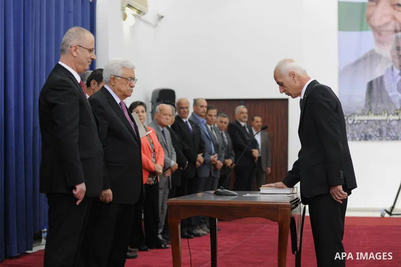 Palestinian President Mahmoud Abbas and the new unity government Prime Minister Rami Hamdallah during the swearing in ceremony of the government at the Palestinian Authority's headquarters in the West Bank town of Ramall...