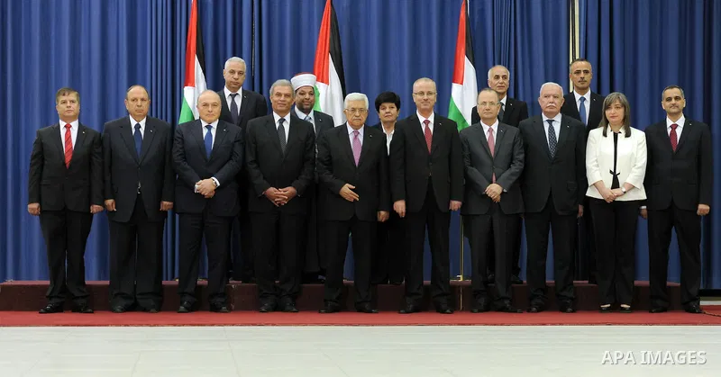 Palestinian president Mahmud Abbas (C) poses for a picture with the members of the new Palestinian unity government in the West Bank city of Ramallah June 2, 2014. Abbas hailed the "end" of Palestinian division as a new...