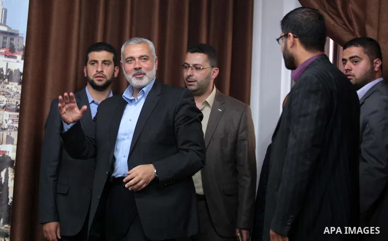 Senior Hamas leader Ismail Haniyeh waves as he leaves his office as a former Hamas government Prime Minister, in Gaza City June 2, 2014. President Mahmoud Abbas swore in a Palestinian unity government on Monday under a r...