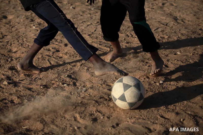 A photo taken on May 26, 2014, shows Palestinian children play football outside their homes, in Deir al-Balah in the central of Gaza Strip. Palestinians share a billion or more people around the globe the feeling of anti...