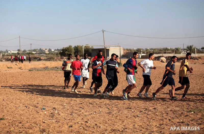 A photo taken on May 26, 2014, shows Palestinian football players exercise during a training, in Deir al-Balah in the central of Gaza Strip. Palestinians share a billion or more people around the globe the feeling of ant...
