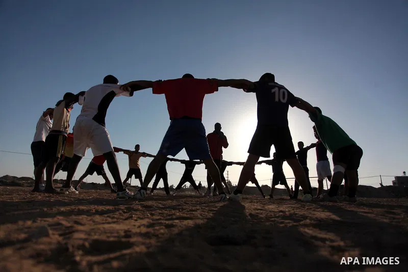 A photo taken on May 26, 2014, shows Palestinian football players exercise during a training, in Deir al-Balah in the central of Gaza Strip. Palestinians share a billion or more people around the globe the feeling of ant...