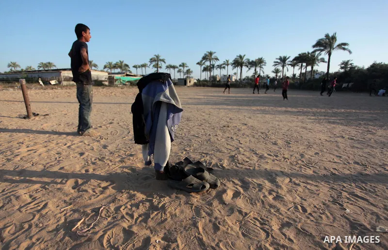 A photo taken on May 26, 2014, shows Palestinian children play football outside their homes, in Deir al-Balah in the central of Gaza Strip. Palestinians share a billion or more people around the globe the feeling of anti...