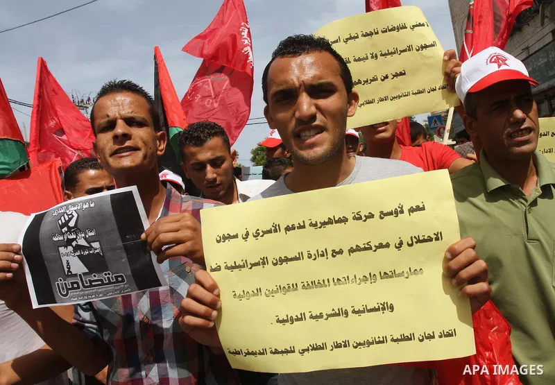 Palestinians hold banners flags during a demonstration to solidarity with Palestinian prisoners held in Israeli jails, in Gaza city, on June 03, 2014. It was about 120 Palestinians imprisoned without trial in Israel on a...