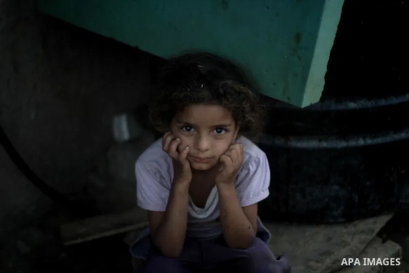 A Palestinian girl pose for a picture outside her house at Al-Zaitoun neighborhood in the central Gaza Strip, on June 02, 2014. Photo by Ezz al-Zanoun