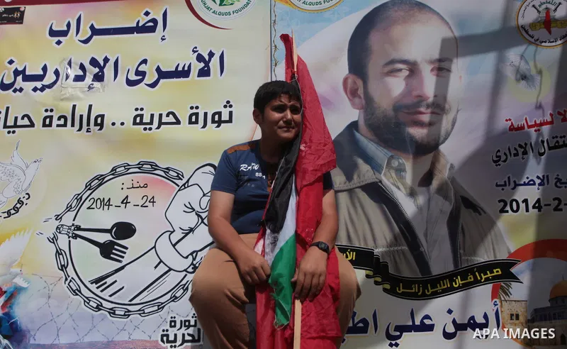 A Palestinian man holds a Palestinian flag during a protest to solidarity with Palestinian prisoners held in Israeli jails, in front of Red cross office Gaza city, on June 03, 2014. It was about 120 Palestinians imprison...