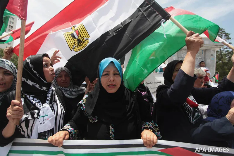Palestinians hold Palestinian and Egyptian flags during a celebrate the announcement of the unity government and former Army chief Abdel Fattah al-Sisi winning the presidential election, in Gaza city on June 03, 2014. Pr...