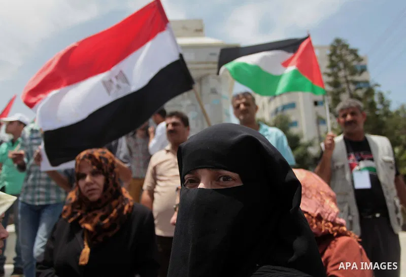 Palestinians hold Palestinian and Egyptian flags during a celebrate the announcement of the unity government and former Army chief Abdel Fattah al-Sisi winning the presidential election, in Gaza city on June 03, 2014. Pr...