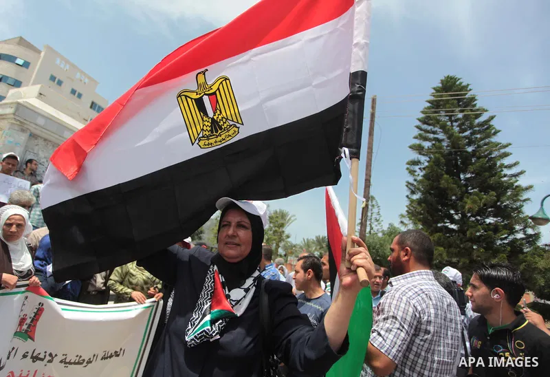 Palestinians hold Palestinian and Egyptian flags during a celebrate the announcement of the unity government and former Army chief Abdel Fattah al-Sisi winning the presidential election, in Gaza city on June 03, 2014. Pr...