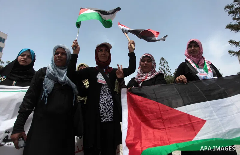 Palestinians hold Palestinian and Egyptian flags during a celebrate the announcement of the unity government and former Army chief Abdel Fattah al-Sisi winning the presidential election, in Gaza city on June 03, 2014. Pr...